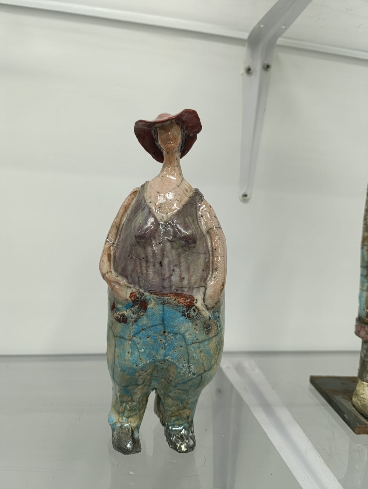 Bambola in ceramica Raku con cappello rosso e tuta azzurra