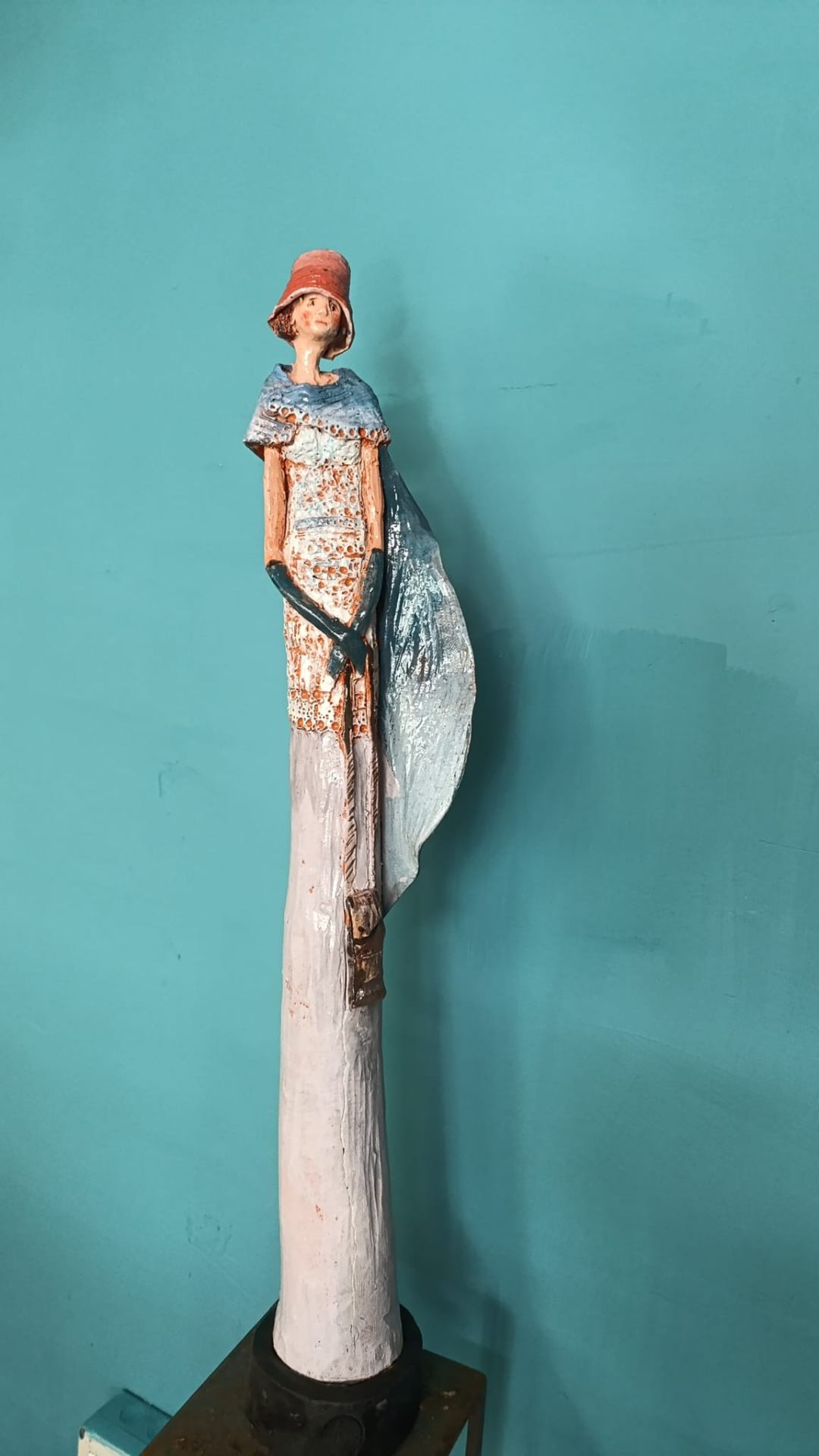 Figura elegante con mantello azzurro e cappello rosso