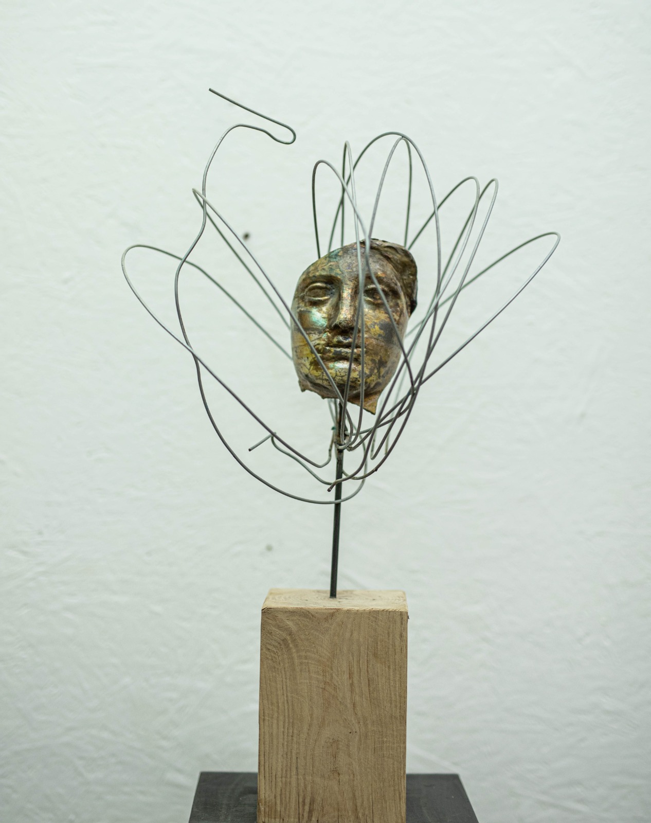 Scultura volto Raku con corona di filo metallico