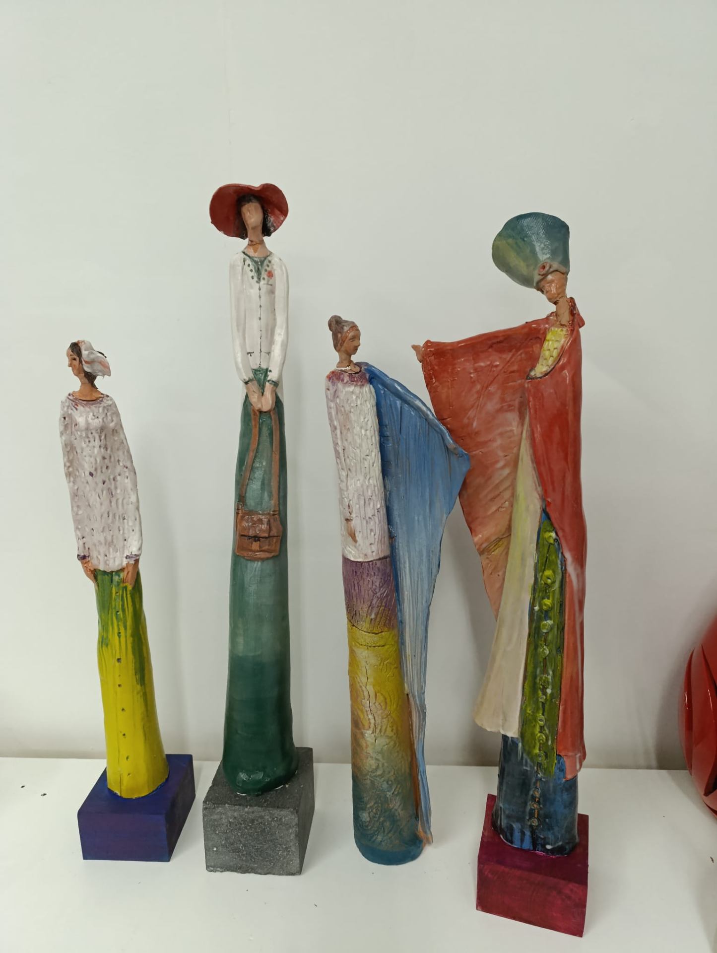 Quattro figure femminili scultoree dai colori vivaci