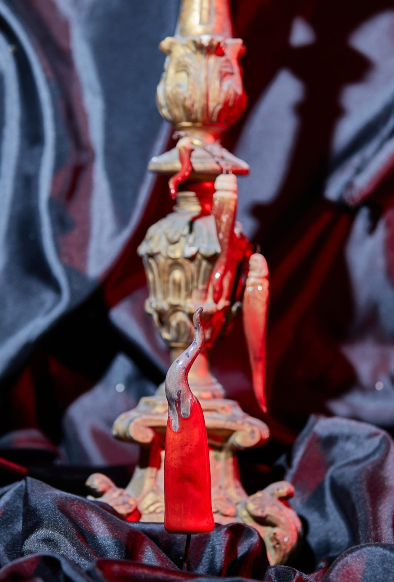 Dettaglio scultura rossa su drappo di velluto scuro