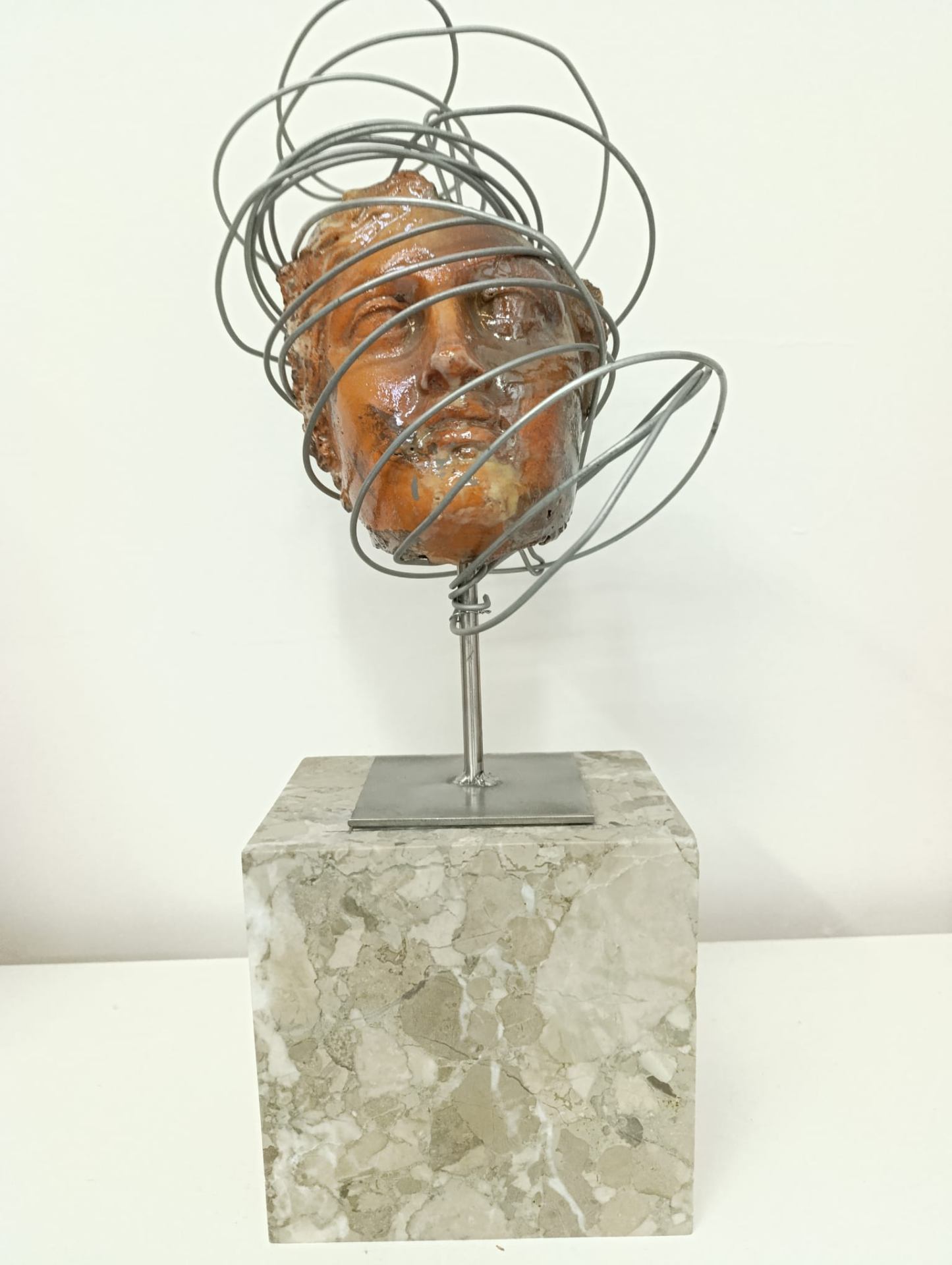 Testa Raku terracotta avvolta da spire metalliche