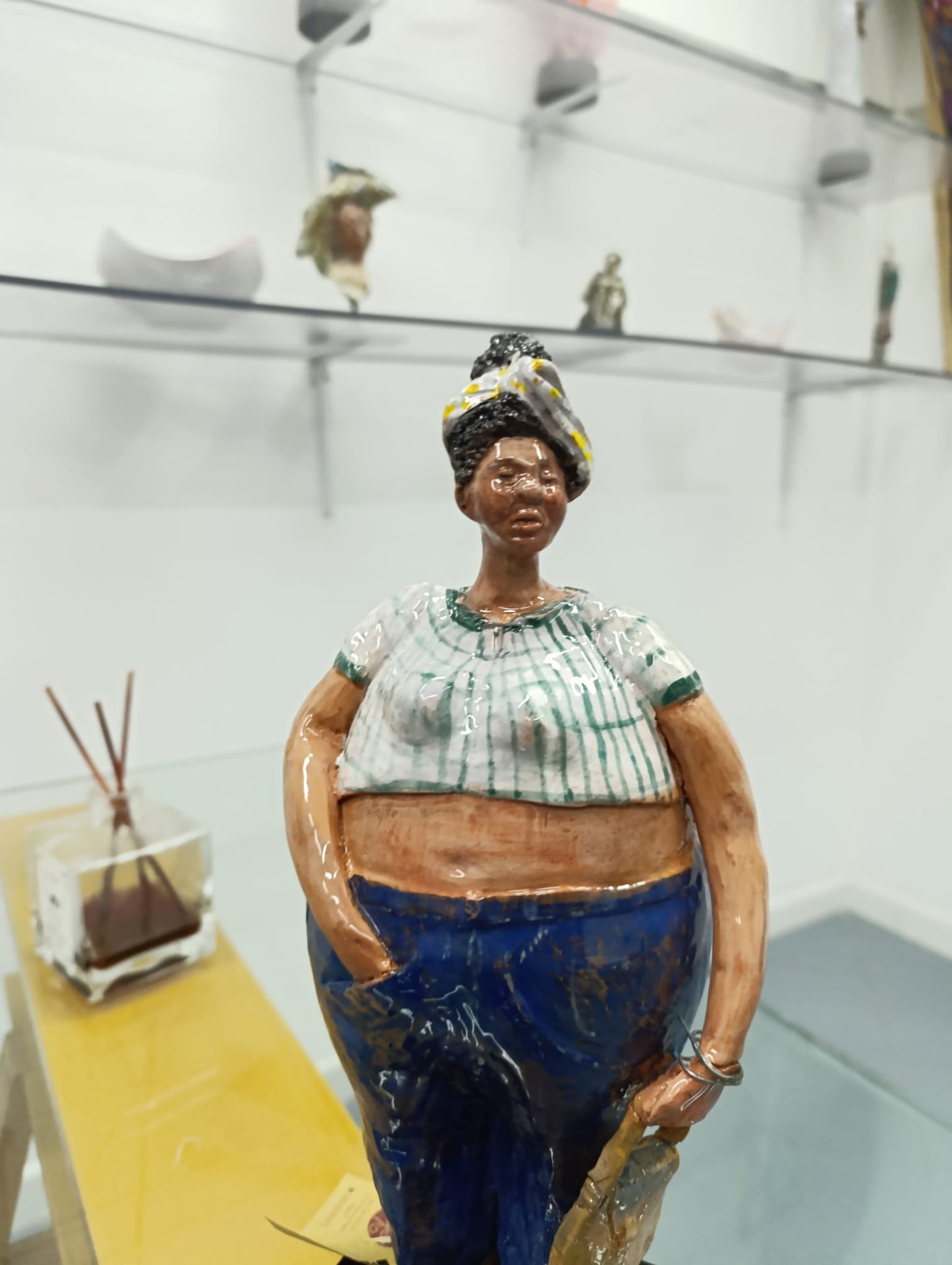 Bambola in ceramica con turbante, blusa a righe verdi e pantaloni blu