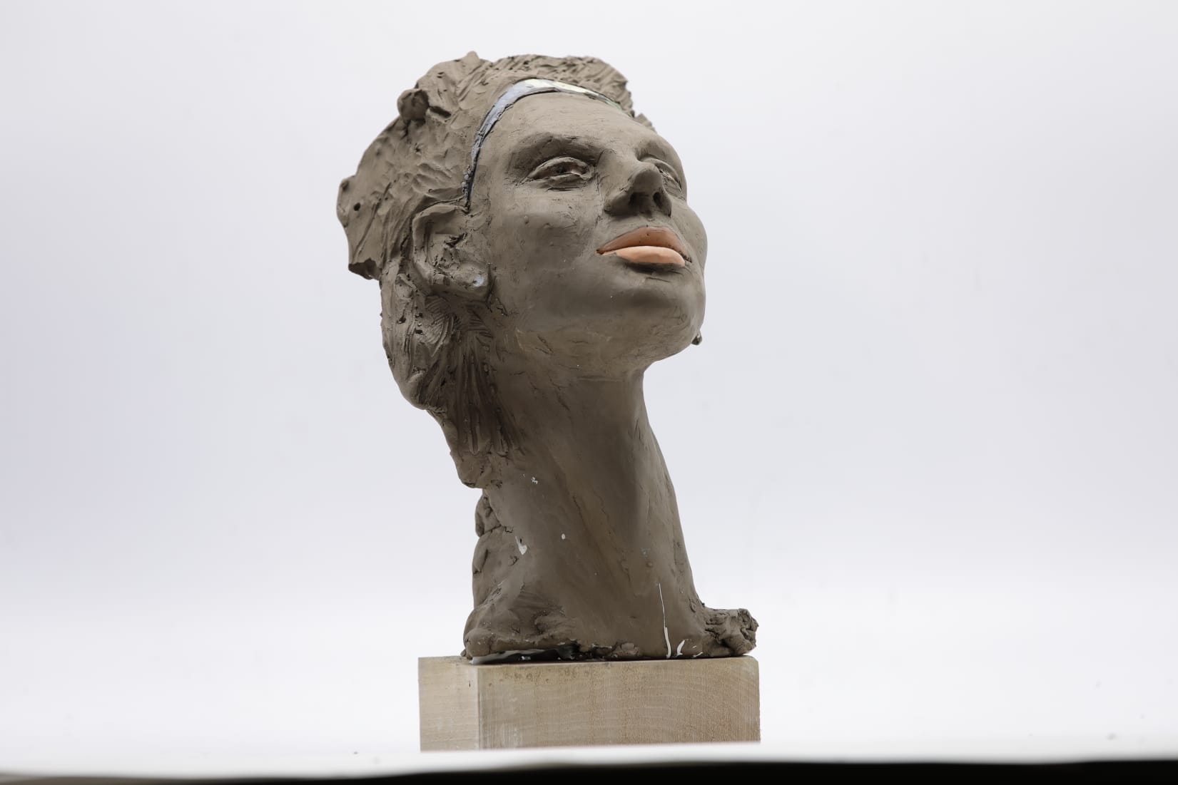 Busto femminile in argilla con labbra colorate