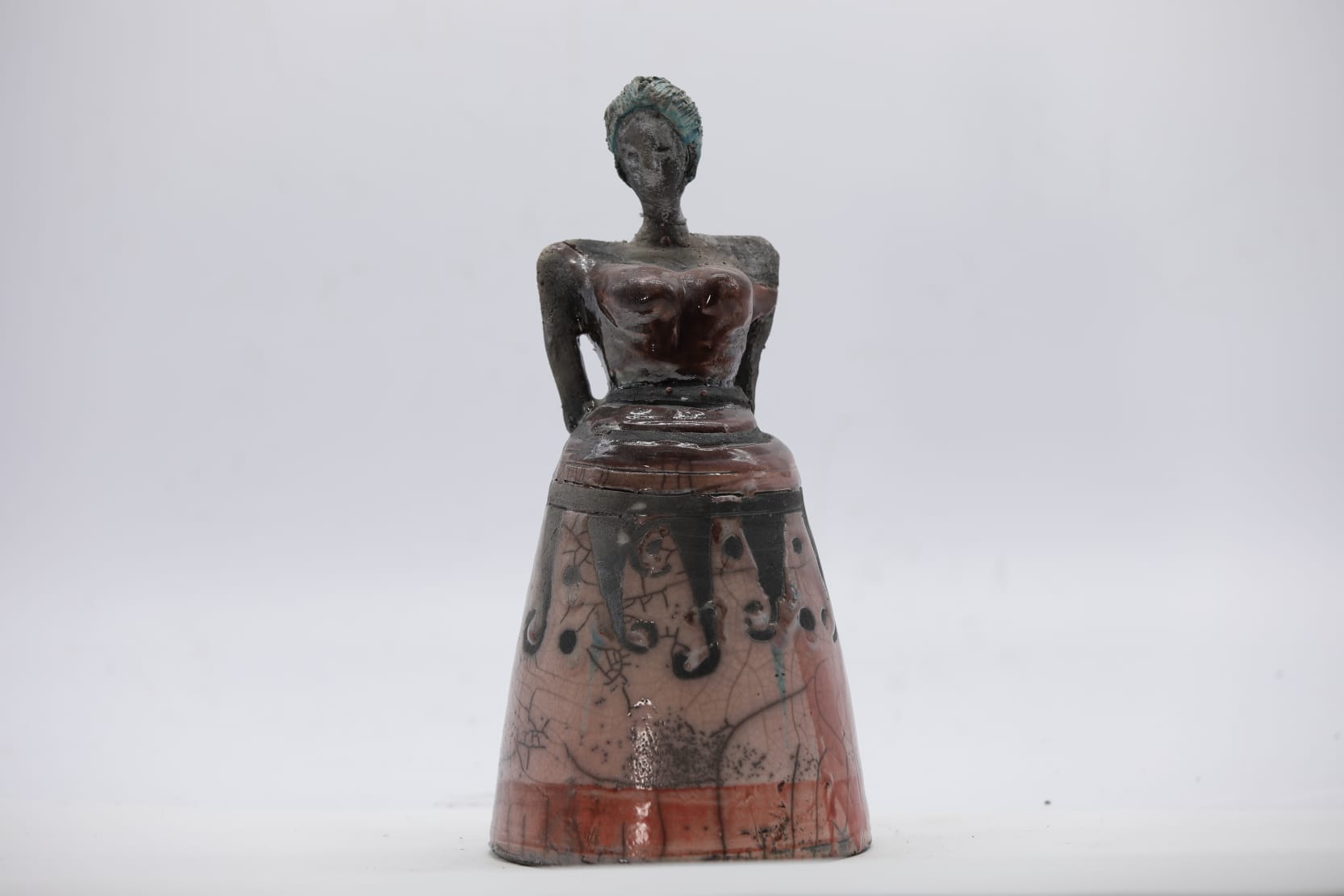 Figura femminile seduta in abito a campana, ceramica Raku