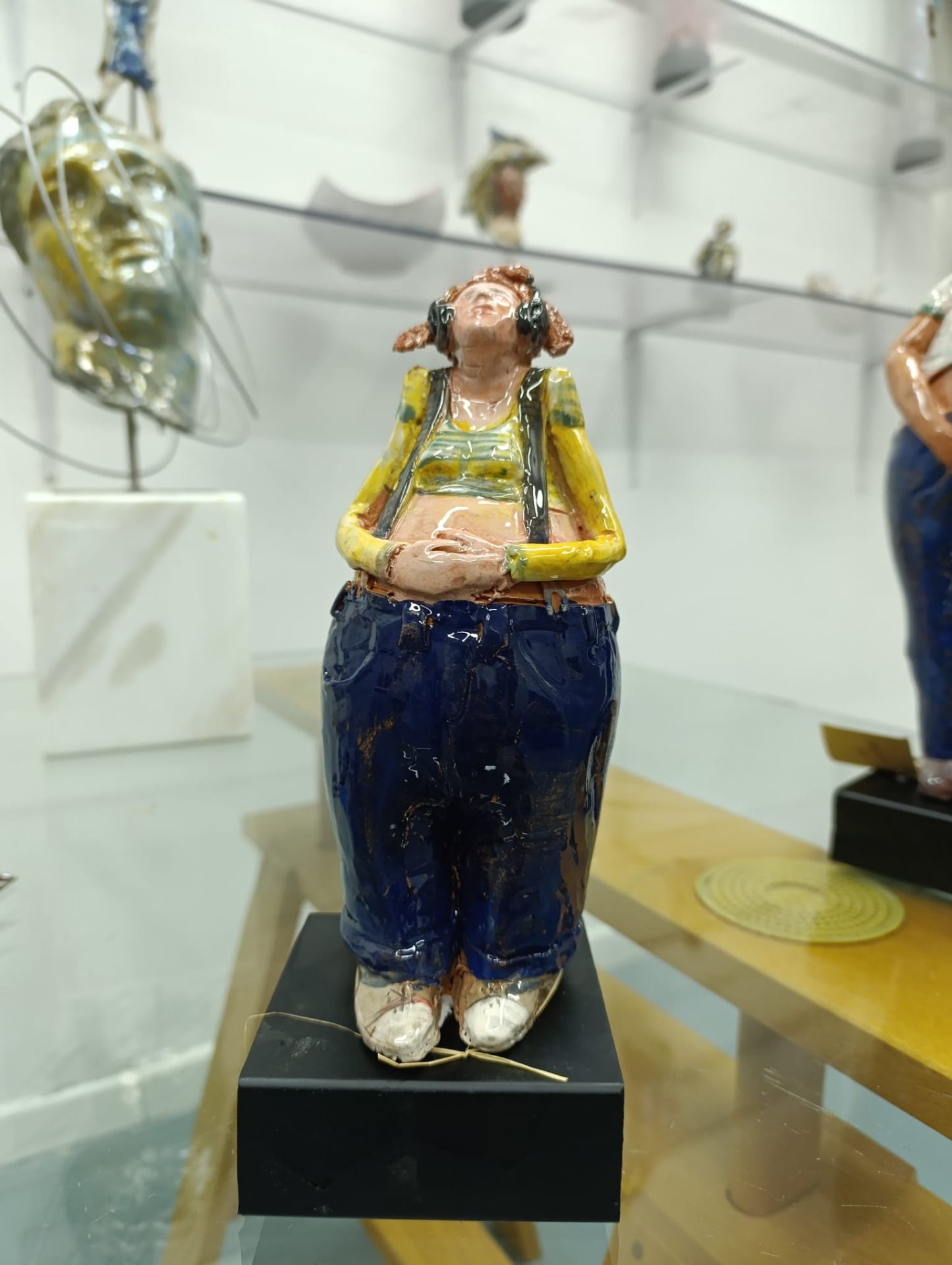 Bambola in ceramica con cuffie, canotta gialla e jeans blu