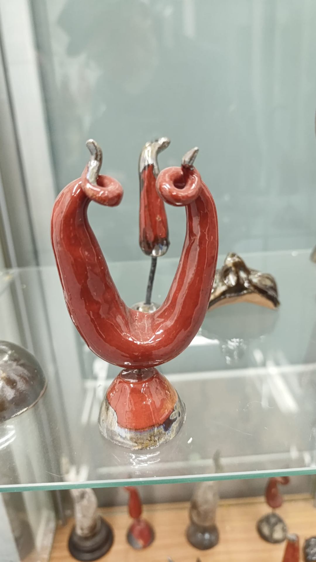 Corno scultoreo in ceramica rossa con punte metalliche su base