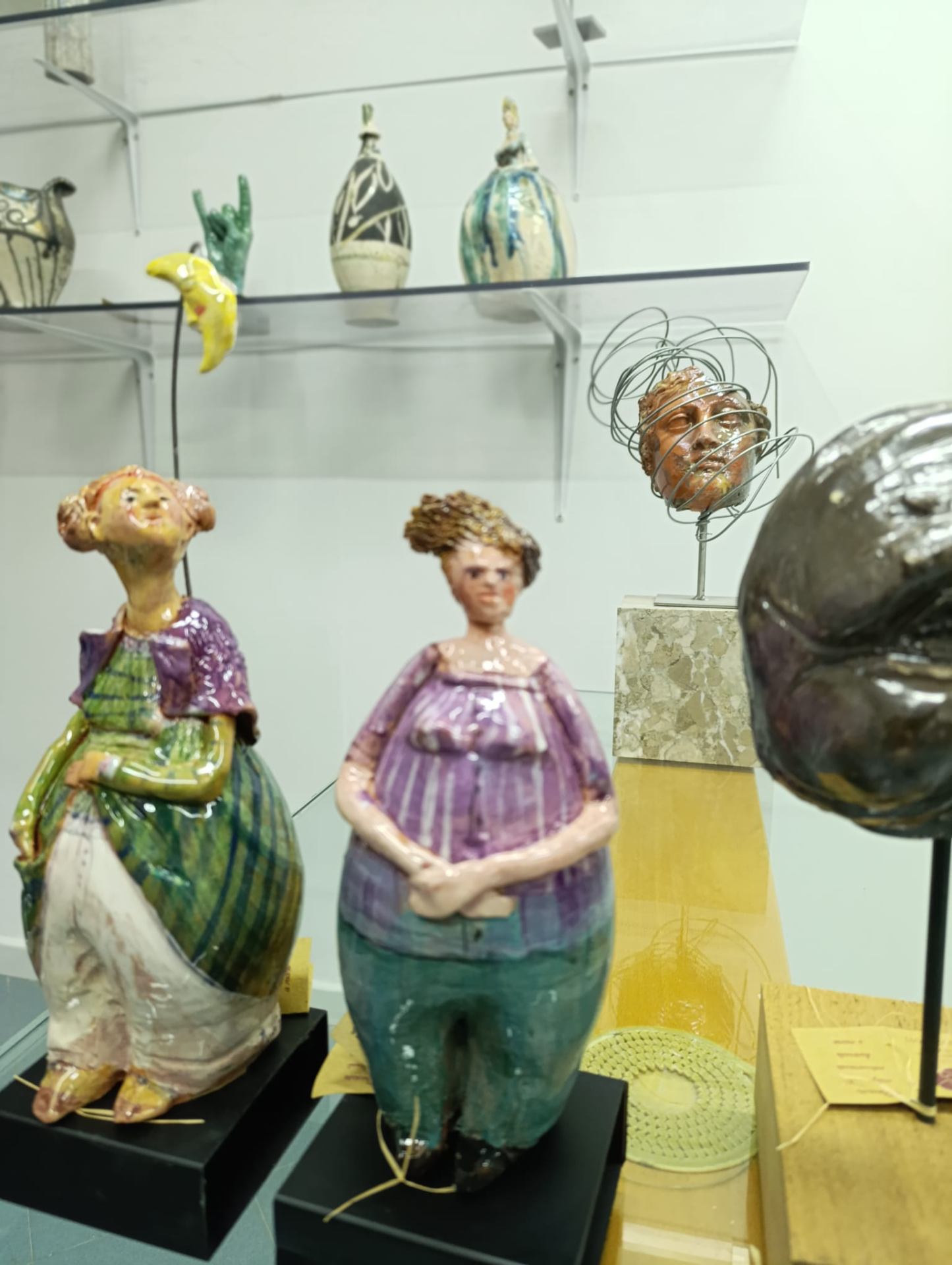 Due bambole in ceramica policroma con abiti viola e verde