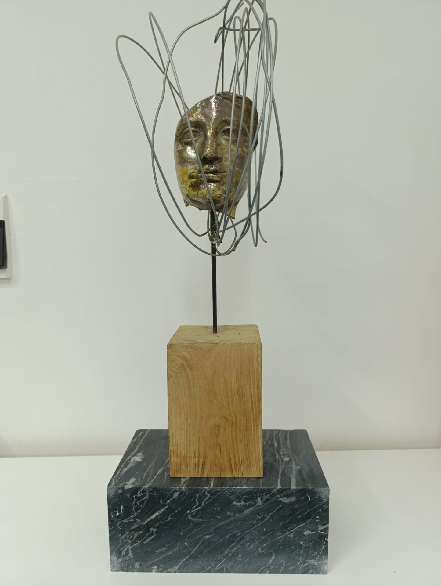 Volto Raku dorato avvolto da fili metallici, base in marmo