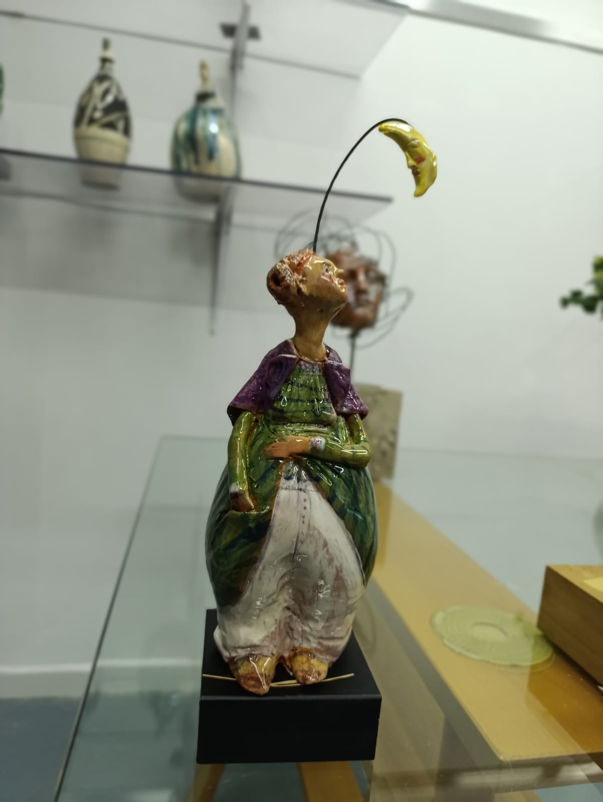 Bambola in ceramica con luna sospesa e abito verde e viola