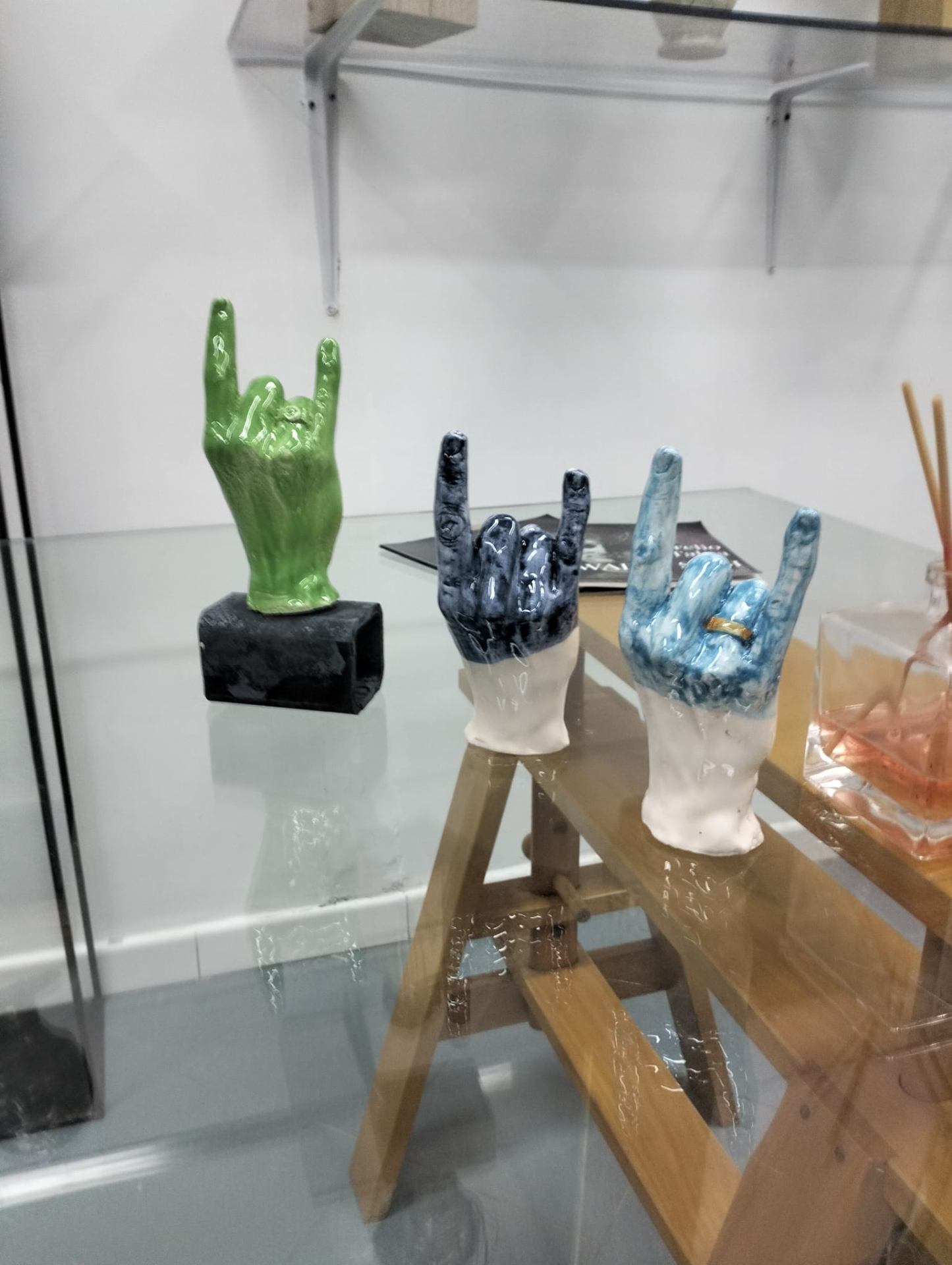 Mani in ceramica con gesto delle corna, verde e blu