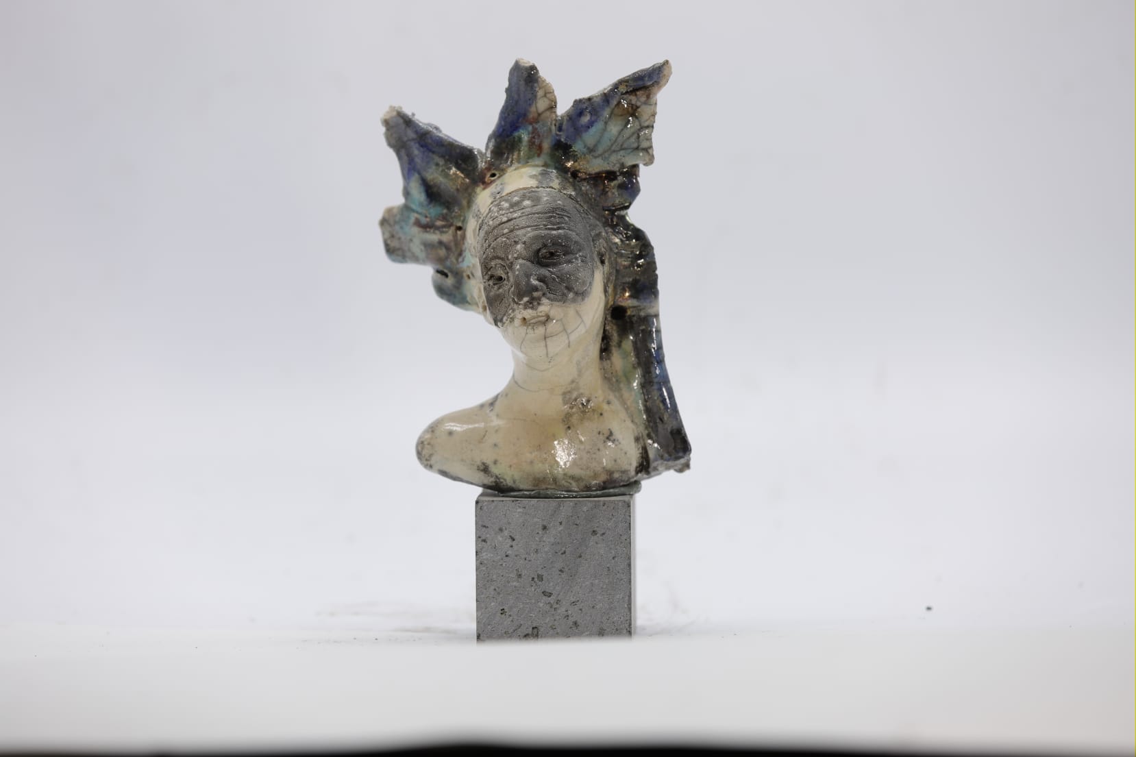 Busto femminile Raku con copricapo blu su base
