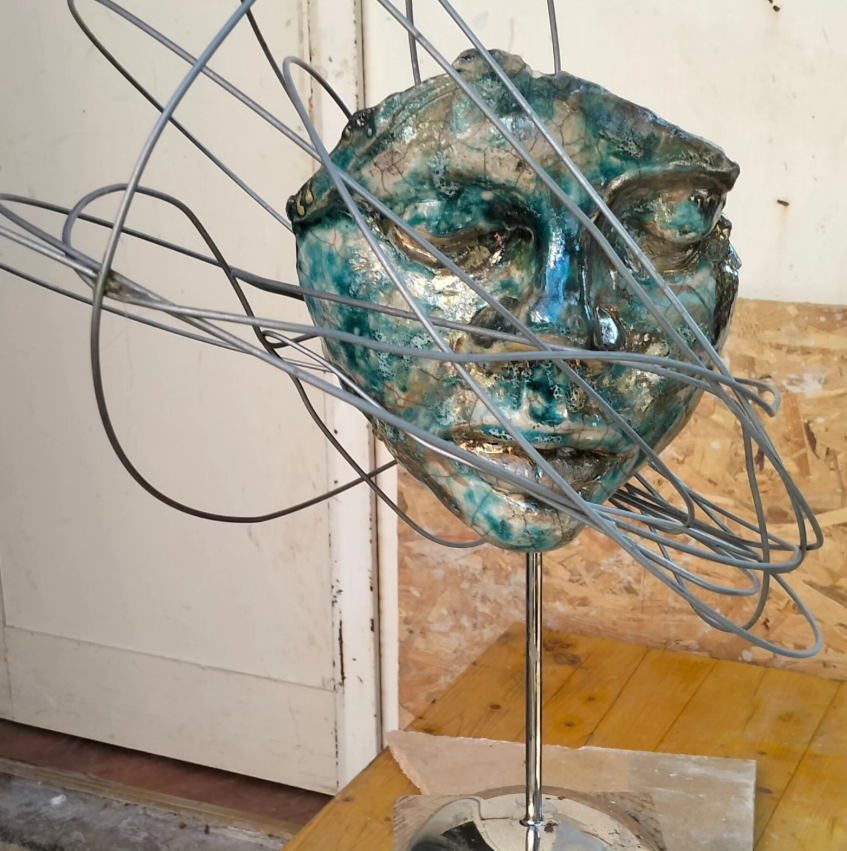 Scultura volto Raku con filo metallico